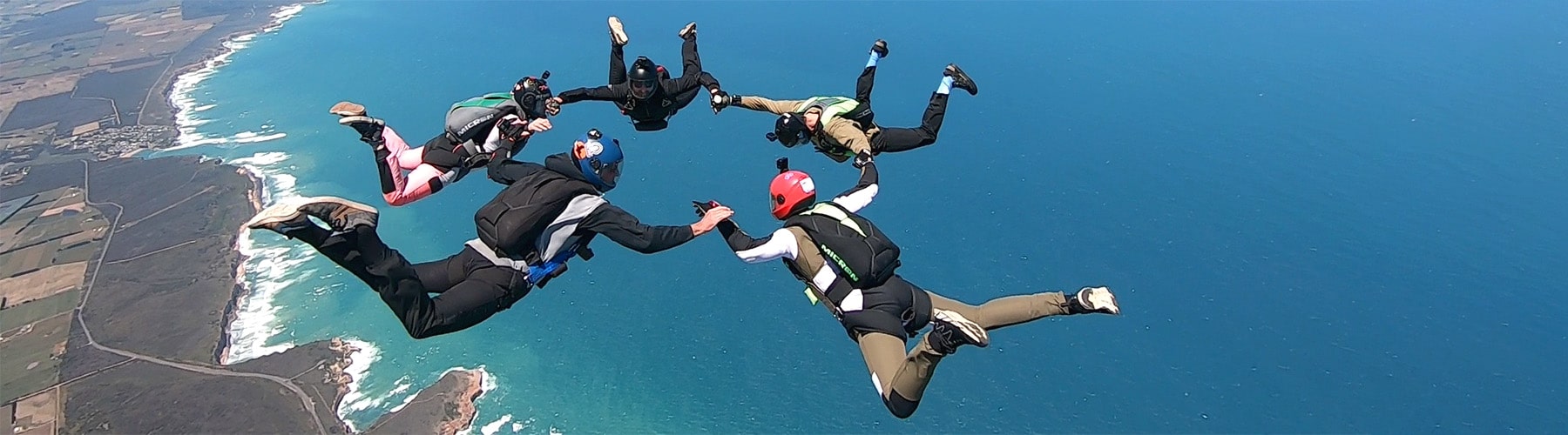 Skydivers in formation over the Great Ocean Road