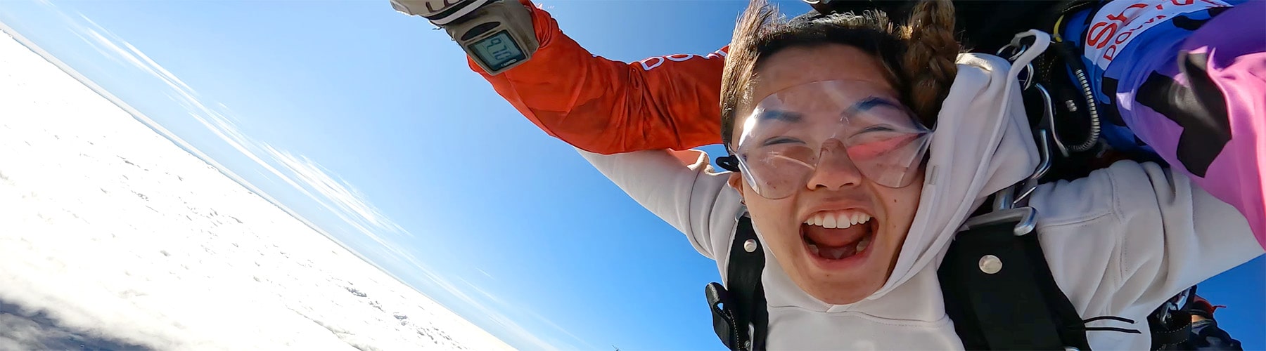 A woman tandem skydiving with a blue sky in Melbourne, Australia