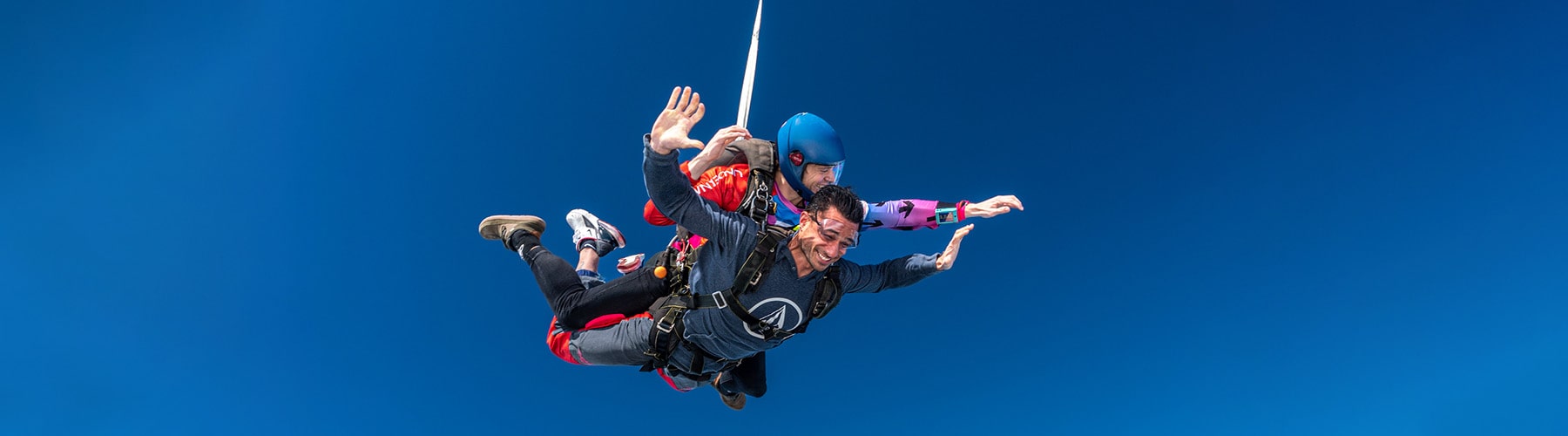 A smiling man doing his first tandem skydive.