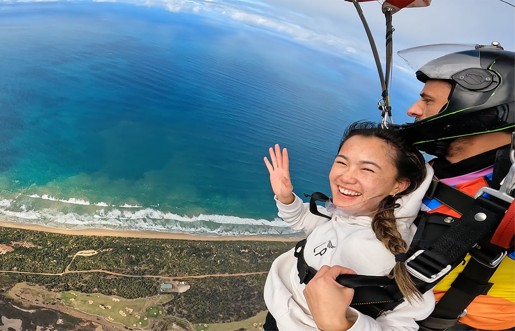 A very happy tandem passenger skydiving with her friends.