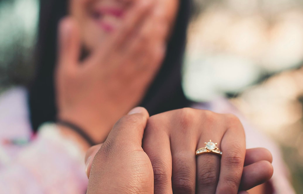 A couple showing off the engagement ring after their skydive marriage proposal.