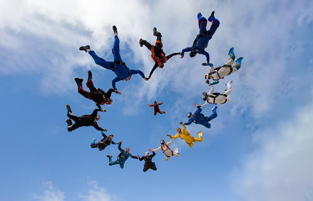 Fifteen skydivers in a formation in the shape of a heart.