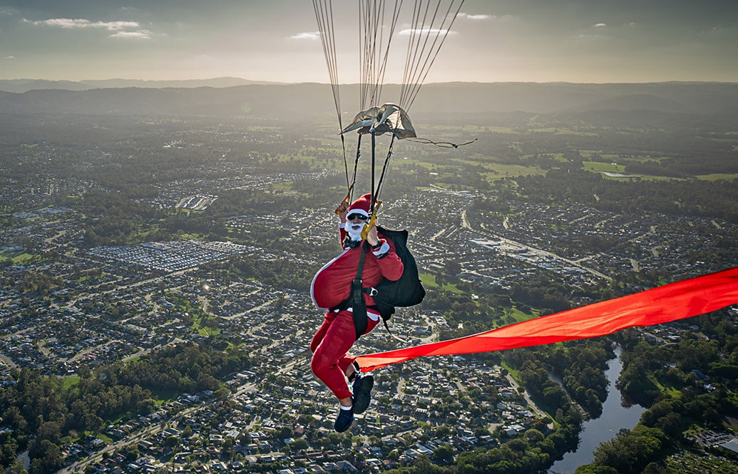 A skydiver dressed as Santa Clause