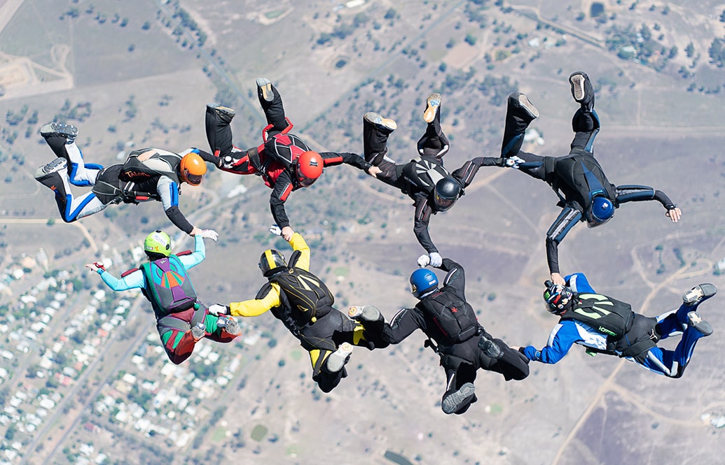 Eight skydivers in formation.