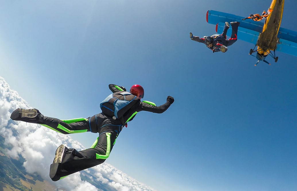 Skydivers in freefall illustrating rig and flight suit.